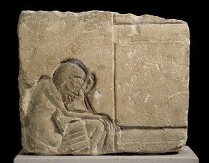 Fragment de calcaire sculpté en relief en creux représentant un serviteur endormi dans le palais